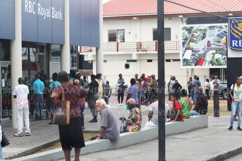 A crowd of people assembled outside commercial bank in Arima not in keeping with social distancing requirements geared at preventing the possible spread of covid19. - Lincoln Holder