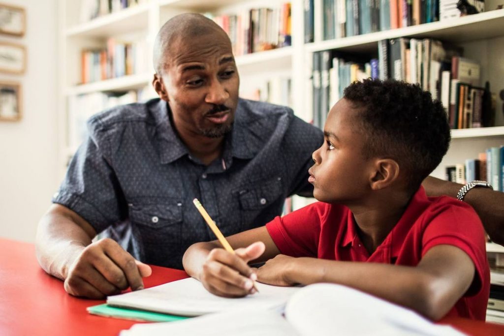 A dad explains a topic to his son in their at-home classroom. Source: www.nationalgeographic.com - 