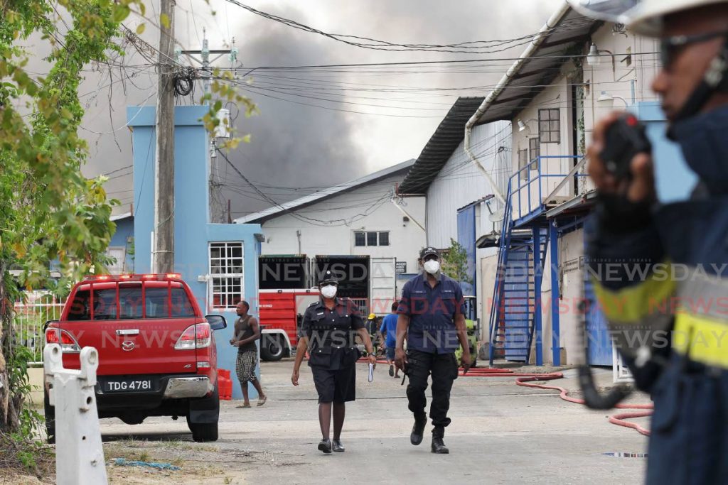 Central divison police and fire officers respond to a fire at Total Recycling Ltd on Endeavour Road, Chaguanas, on Tuesday.  - Lincoln Holder