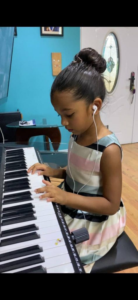 Soleil Mai Suraj makes sure she continues learning to play the piano with online lessons from her teacher, Johanna Chuckaree. Photos courtesy April Suraj - April Suraj