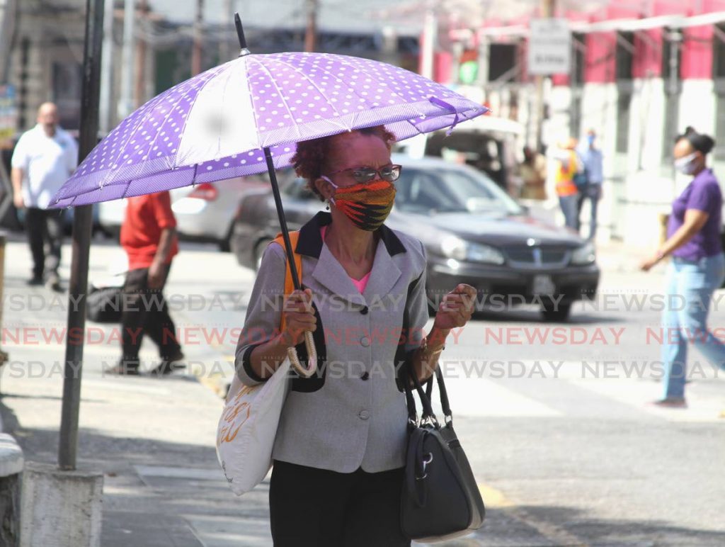 A woman walks though Port of Spain wearing a face mask. When it is safe for employees to return to work, covid19 protocols may have to be continued to minimise the risk of further spread. - Ayanna Kinsale