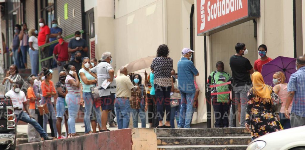 NO SOCIAL DISTANCING: Dozens of people stand shoulder to shoulder outside the Scotiabank in San Fernando.  - L Holder