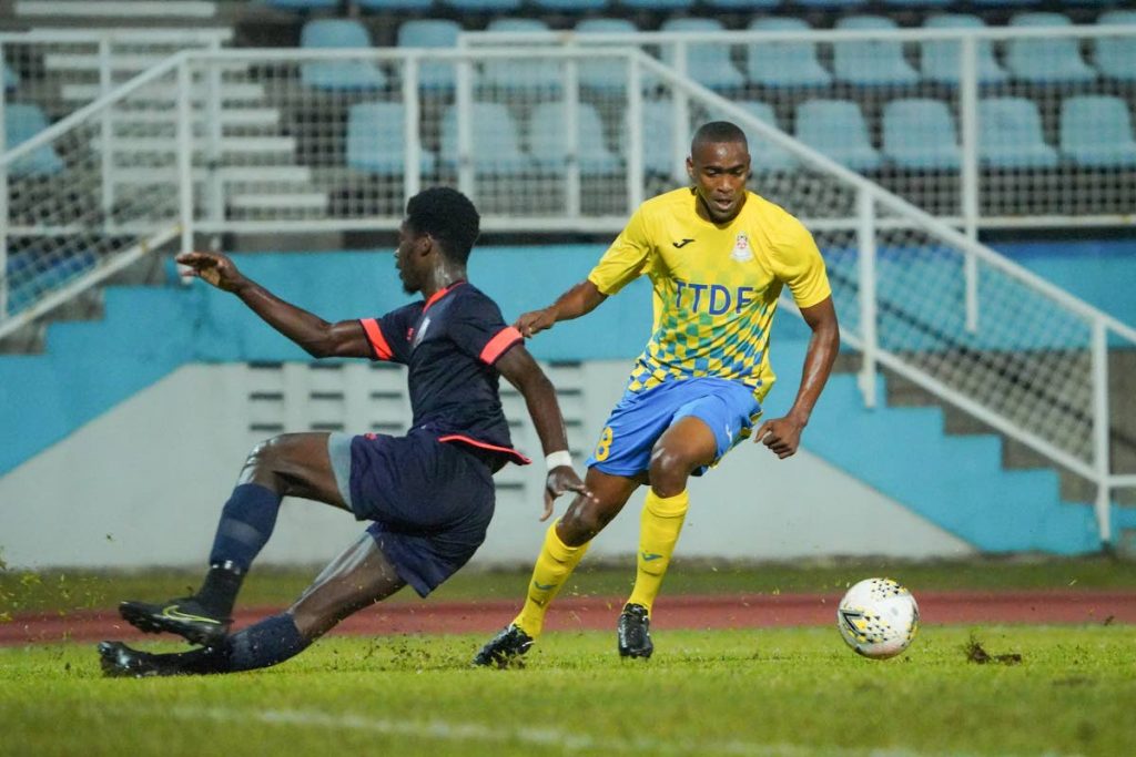 In this Feb 14 file photo,  Defence Force Reon Moore (right) dribbles past Athletic Club POS defender Jokiah Leacock during the TT Pro League match between Defence Force FC and Athletic Club POS at the Ato Boldon Stadium, Couva. Defence Force won 3-1.  - Daniel Prentice/CA-images