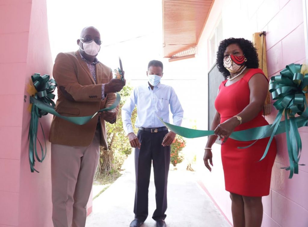 Chief Secretary Kelvin Charles, left, cuts the ribbon for the recommissioning of the Black Rock Multipurpose Regional Complex  as Secretary for Community Development Marslyn Melville-Jack, right, and Black Rock Village Council president Larry Paul look on. - THA