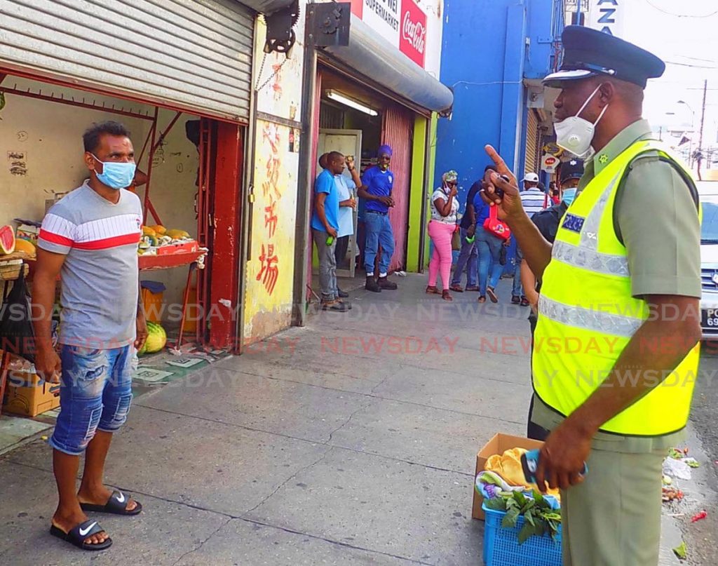 FACE-OFF: Head of Port of Spain Division, Snr Supt Daniel Moore, outlines social distancing guidelines to a vendor along Charlotte Street on Friday afternoon. PHOTO BY SHANE SUPERVILLE - Shane Superville