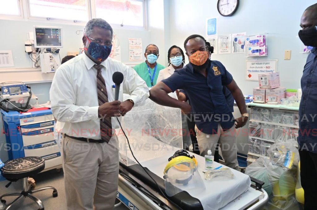 OWTU executive vice president Marcus Cordner, right, and Scarborough General Hospital's Medical Chief of Staff Dr Victor Wheeler touch elbows after OWTU donated personal protective equipment to the hospital on Tuesday. - LEEANDRO NORAY