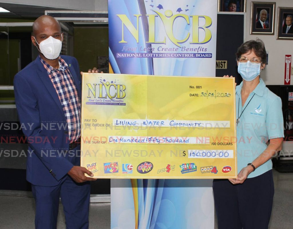 NLCB sponsorship committee chairman, Dwight Andrews, presents a replica of the cheque to Living Water Communnity assistant director, Rose Mary Scott, at NLCB's Duke Street, Port of Spain office on Thursday.  - Angelo Marcelle