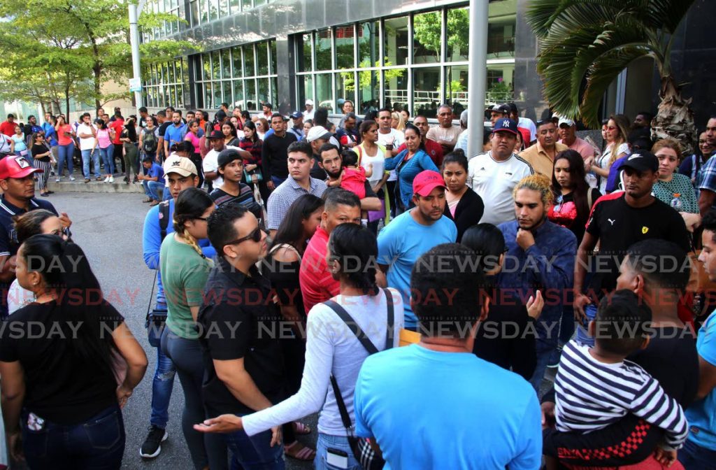 In this December 2019 file photo, Venezuelans wait to collect their registration cards outside the Ministry of National Security building on lower Richmond Street in Port of Spain. National Security Minister Stuart Young said 16,523 Venezuelans were registered in TT in May-June 2019, with a six-month extension granted in early 2020 for those who were issued national registration cards. Previous estimates by the UNHCR, however, had suggested nearly 40,000 migrants were in the country. - SUREASH CHOLAI