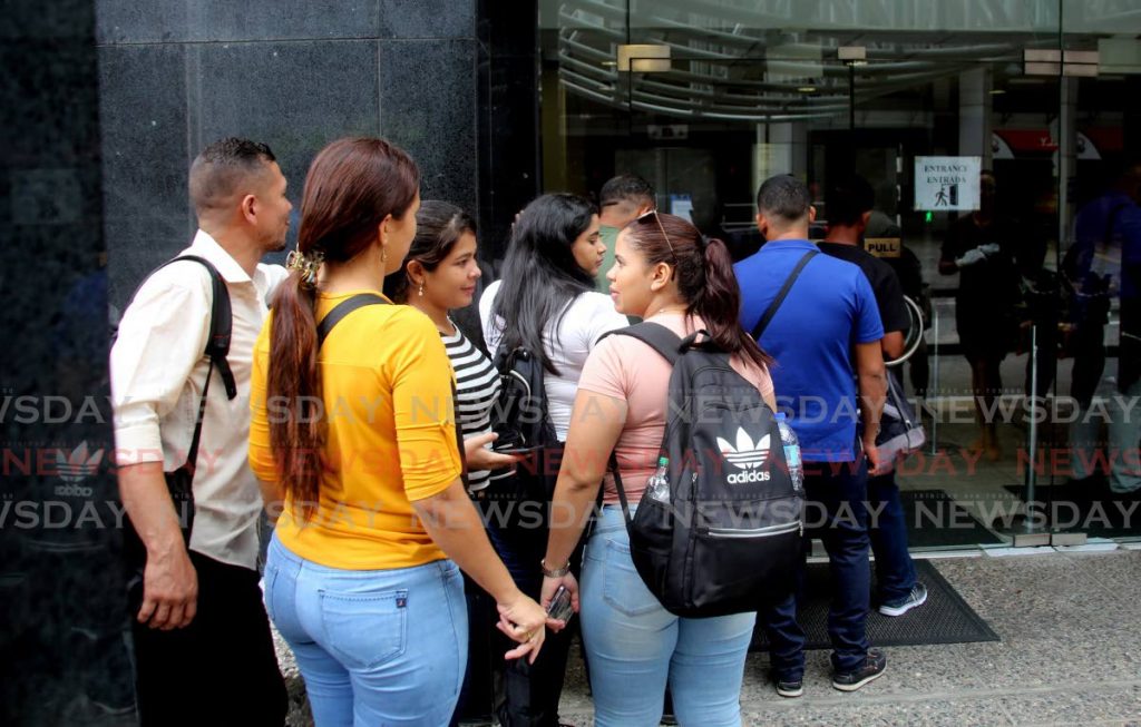 FILE: Venezuelan nationals line up outside the Ministry of National Security last year  to collect registration cards which allows them to work and live in this country for up to one year. - SUREASH CHOLAI