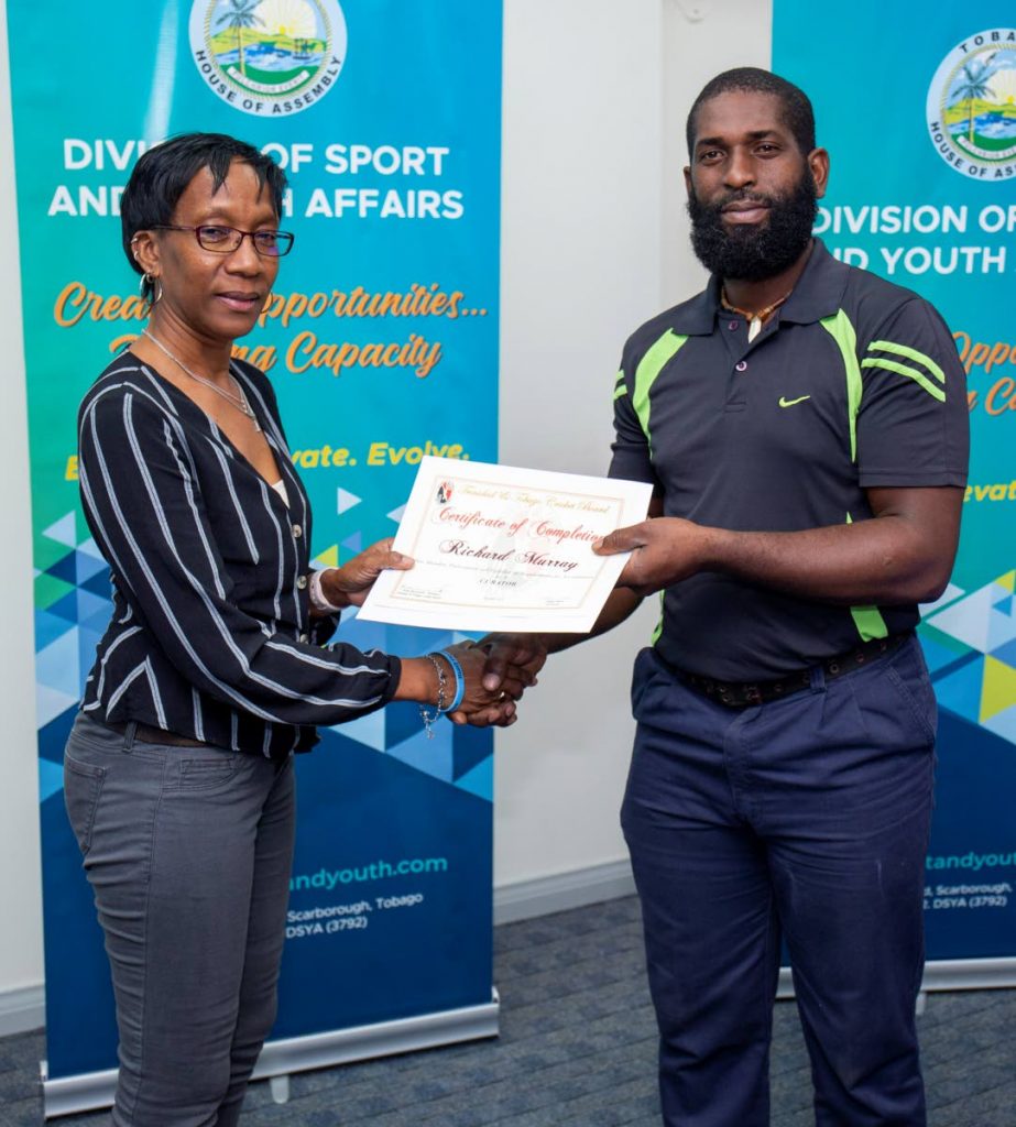 Cricket Pitch Attendant at Louis D'or, Richard Murray (right), receives his certificate of participation in the Workshop for Cricket Pitch Curators from Technical Director of Sport, Mrs. Lyndell Hoyte-Sanchez in Shaw Park, Scarborough recently. PHOTO COURTESY DIVISION OF SPORT AND YOUTH AFFAIRS. - 
