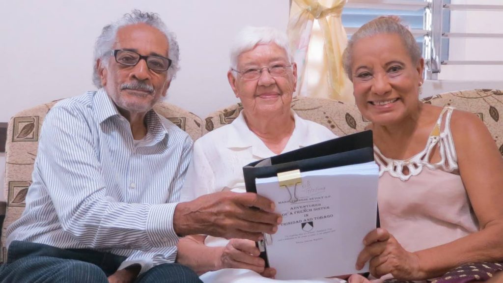 From left, Owen Baptiste, Sister Marie Thérèse Rétout and Rhona Baptiste looking at the manuscript of the biography in 2018. - Delia Mendez