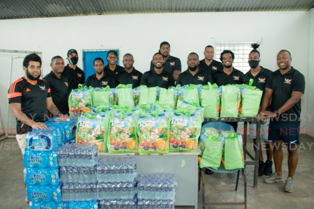 Members of the Woodford Sweaters Football Club stand near food hampers collected for distribution to families in need in Chaguanas last Saturday. 

PHOTO COURTESY WOODFORD SWEATERS FOOTBALL CLUB - Shane Superville