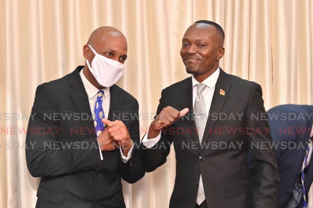 Sport Secretary Jomo Pitt, left, congratulates new Chief Secretary Ancil Dennis with a touch of elbows at the Assembly Legislature on Wednesday. PHOTO BY LEEANDRO NORAY  - 