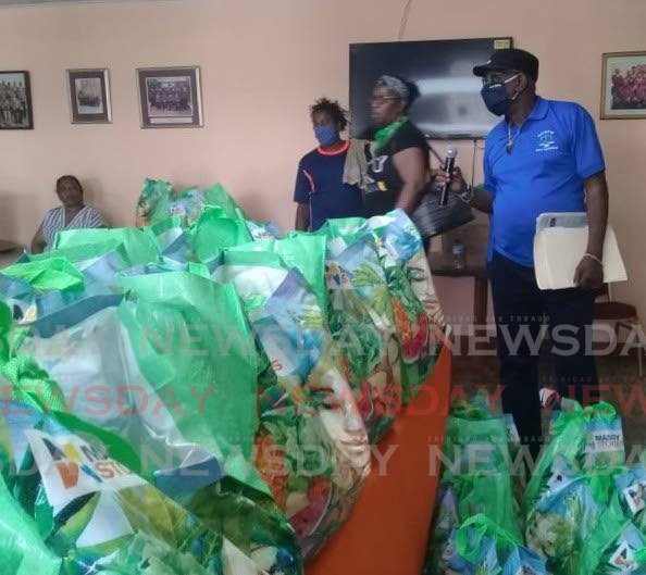President General of the NUGFW James Lambert, right, stands beside a table filled with food hampers donated by Massy Stores to the union to be distributed to workers who lost their jobs because of the coronavirus outbreak. PHOTO BY SHANE SUPERVILLE  - Shane Superville