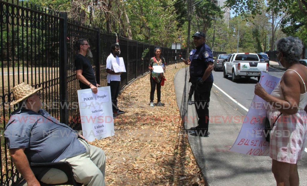 Protestors, including former Arima mayor Ghassan Youseph (left), and political activist Phillip Franco, who gathered outside the entrance to the PM’s official residence in St Ann’s calling for Government to allow more businesses to reopen.  - ROGER JACOB