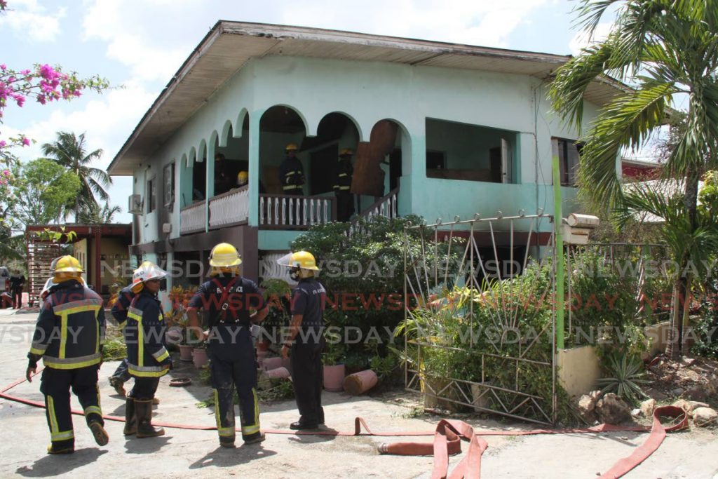 Fire officers from the Couva and Point Lisas fire stations at the scene of the fire which gutted a two-storey  house at  McBean,  Couva. - Vashti Singh