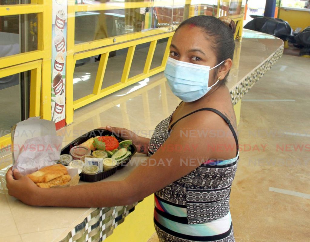 A customer gets ready to have her bake and shark which she bought from Uncle Sam's at Maracas Bay Village on Friday.   - Ayanna Kinsale