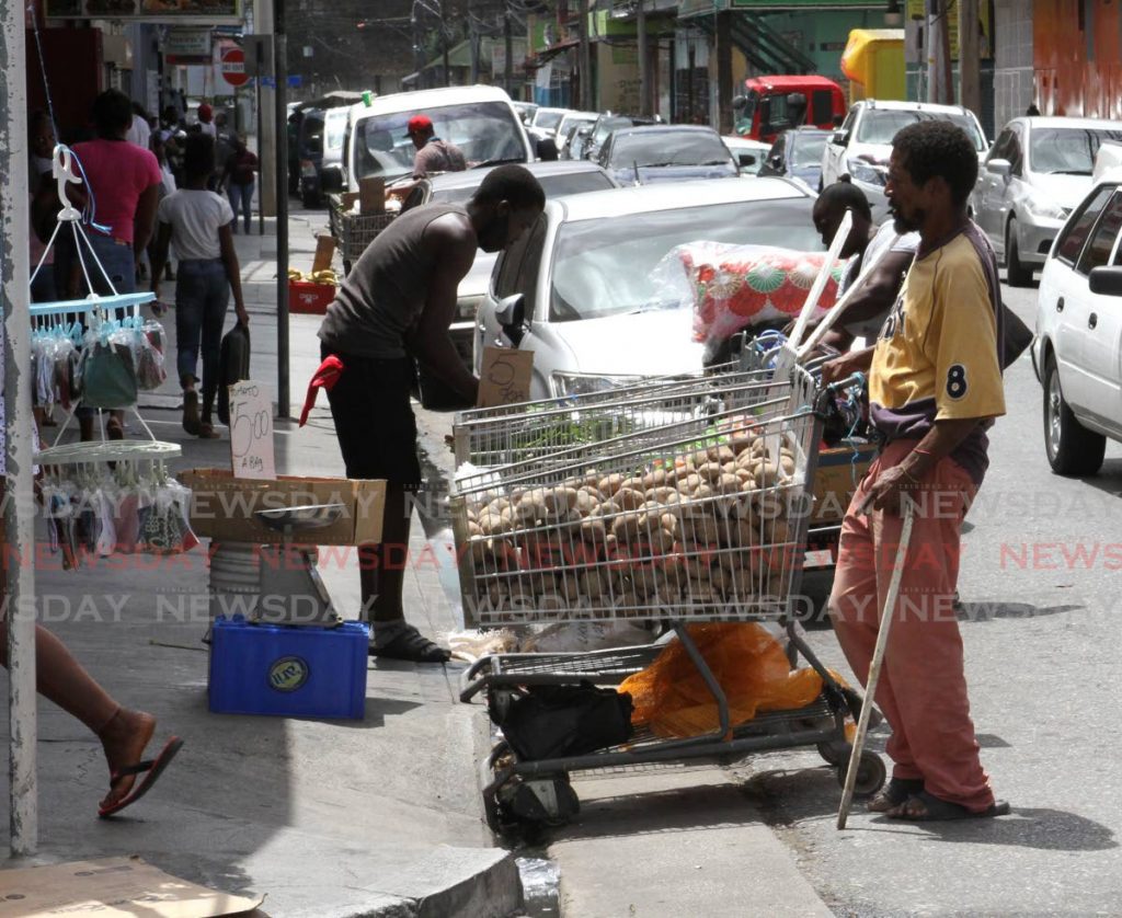 Street vendors carry out their business on Charlotte Street, Port of Spain on Saturday. - Angelo Marcelle