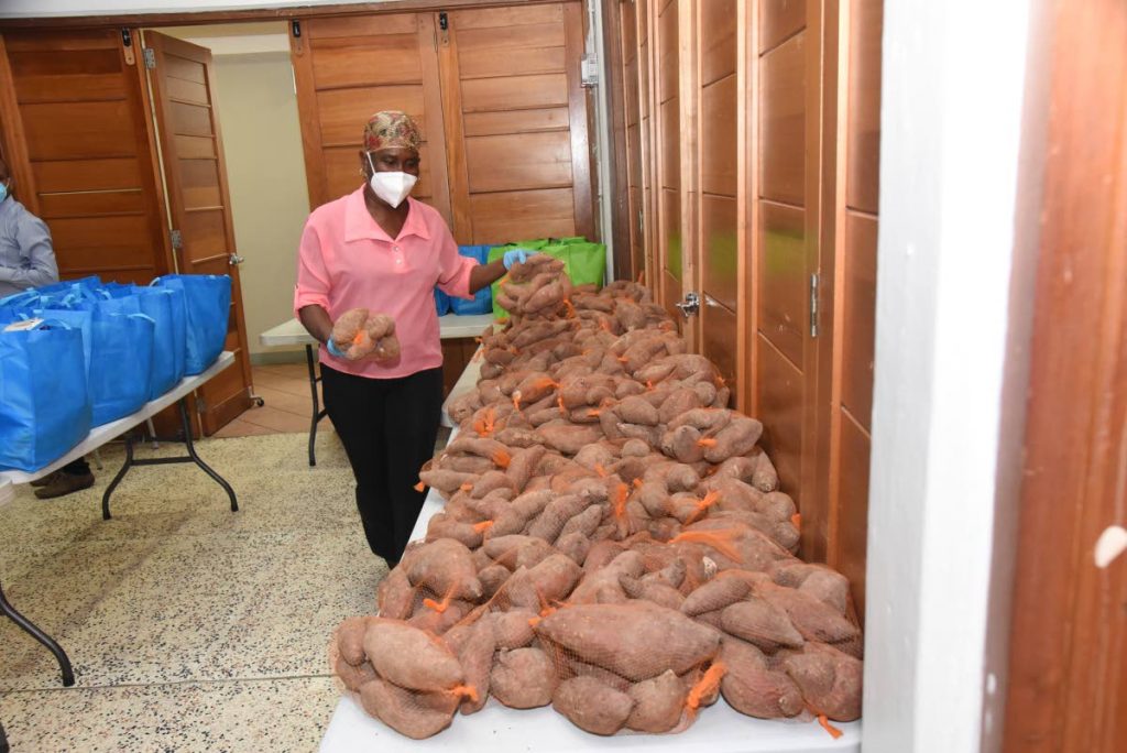 A volunteer assorts sweet potatoes to be packed in food hampers for distribution across TT through food banks set up by BPTT and the Rose Foundation. 
 - 