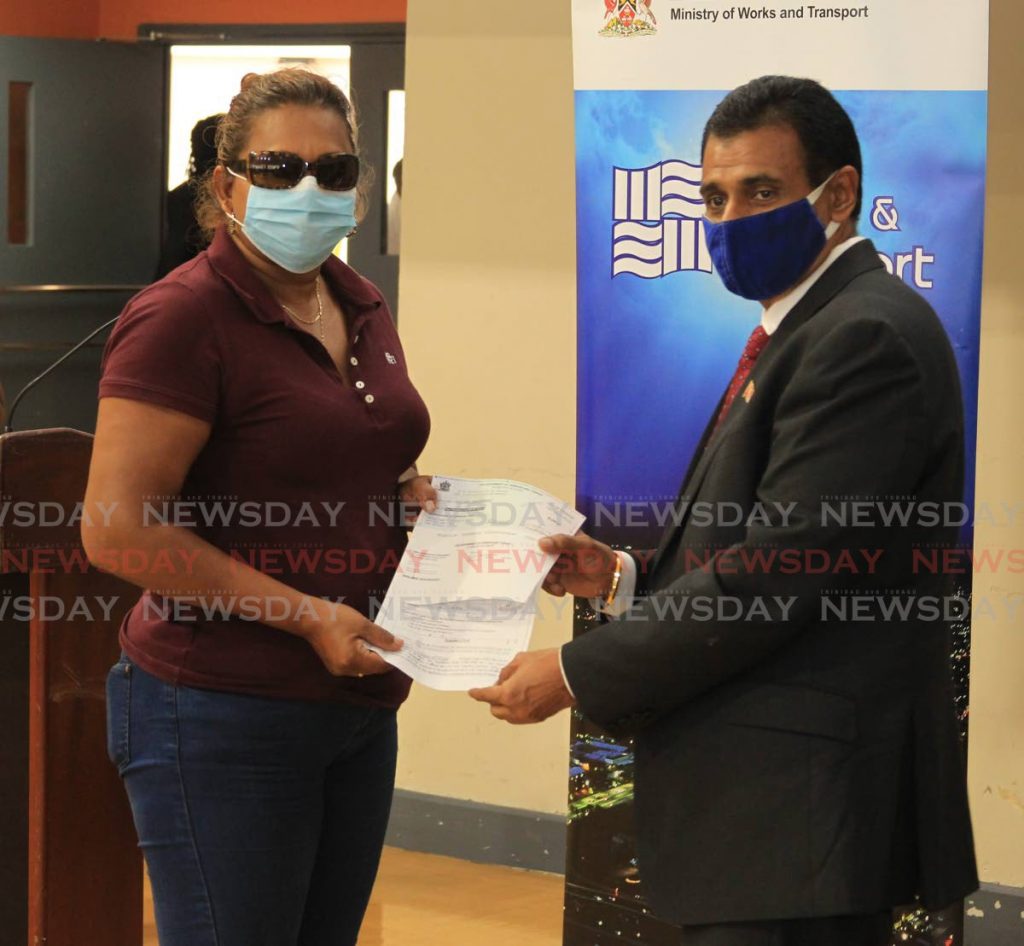 Minister of Works and Transport Rohan Sinanan presents a fuel-grant cheque for $2,000 to maxi-taxi operator Jebourdsingh Doolarie during a ceremony at the Ministry of Works and Transport, Richmond Street, Port of Spain on Friday. - ROGER JACOB