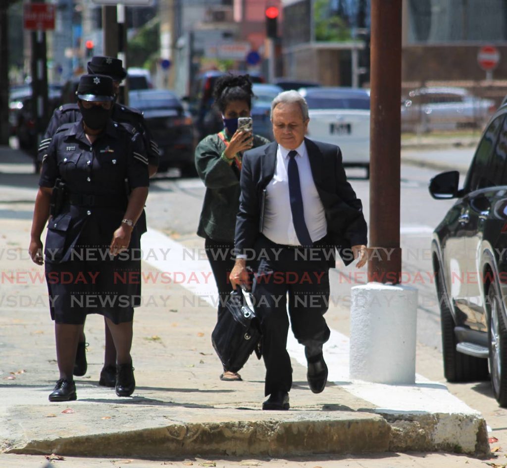 GREAT ESCAPE: Minister of Finance Colm Imbert sets off on a short jog as he tries to avoid social activist Nazma Muller when she confronts him about marijuana-related legislation outside the Red House on Abercromby Street, Port of Spain, in May, as two police officers look on. - ROGER JACOB
