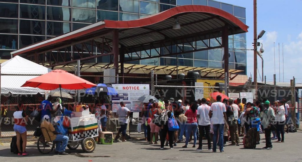 Standby passengers outside the entrance of the Port of Spain Ferry Terminal await access to purchase a ticket to board the MV Jean de la Valette on Sunday. PHOTOS BY ROGER JACOB  - 