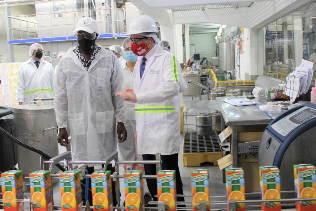 Prime Minister Dr Keith Rowley listens as Patricio Torres, Nestlé head of market in the Anglo Dutch Caribbean, details the company’s operations during a visit on Wednesday. PHOTO COURTESY OPM - OPM