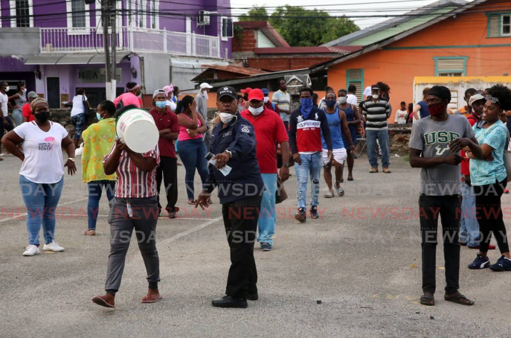 A police officer assists those who went for help at the Living Water Community on Friday. PHOTO BY SUREASH CHOLAI - 
