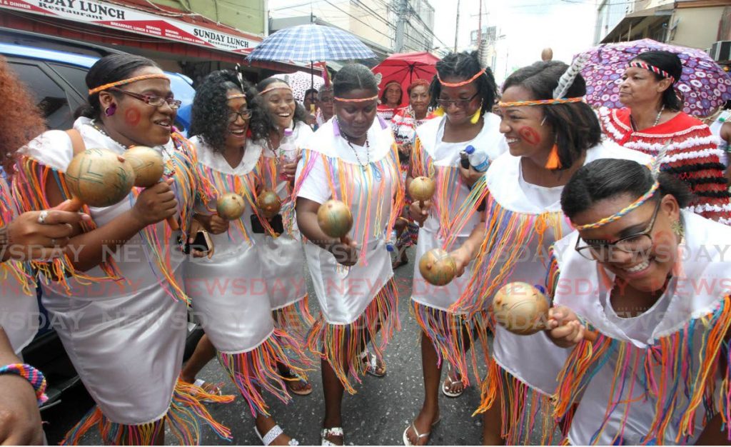 In this August 18, 2019, members of the Santa Rosa First Peoples Performing Company dance through the streets of Arima during Carifesta.  - 