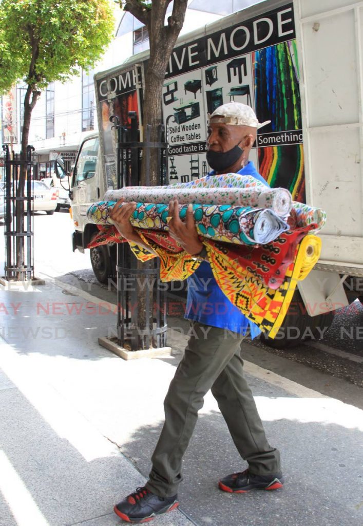 A man delivers bales of fabric to Mode Alive store, Frederick Street, Port of Spain when the retail sector reopened on June 2. Finance Minister on Saturday gave details of a $300 million loan facility and other financial support for small and medium-sized businesses. - ROGER JACOB