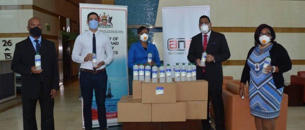 Director of petroleum management operation division Marc Rudder, Ansa Merchant Bank head of business development Edmund Joachim, Ministry of Energy and Energy Industries PS Penelope Bradshaw Niles: Ansa Merchant Bank MD Gregory N Hill and deputy PS Sandra Fraser during a handover by the bank of hand sanitiser supplies to the ministry.  - 