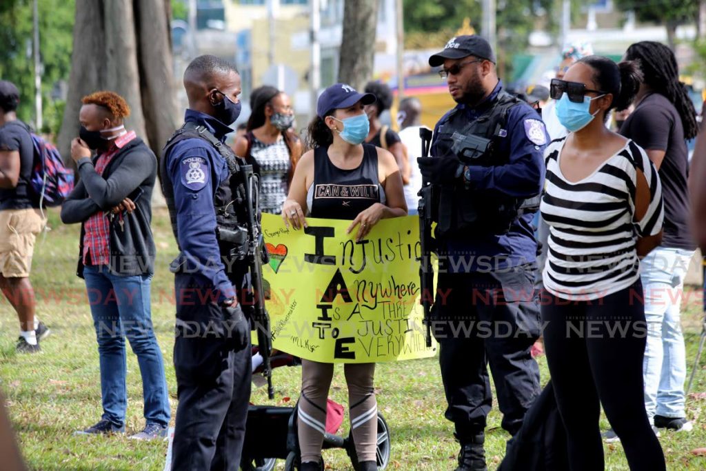 Police interact with Black Lives Matter protesters at Queen's Park Savannah, Port of Spain on June 8, 2020. - 