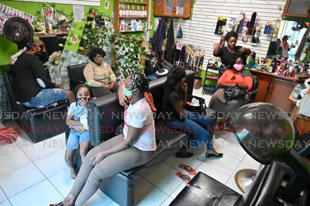 Customers wait their turn at Sharma Beauty Salon which reopened on Monday in Scarborough. - LEEANDRO NORAY 