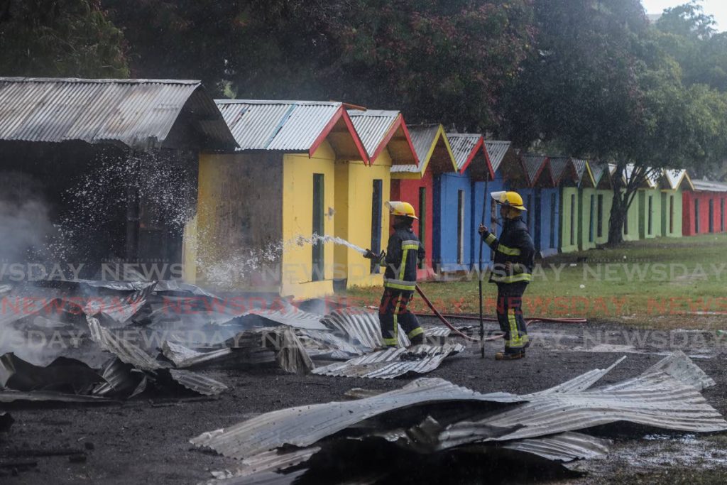 Fire officers at the scene of the blaze which destroyed some of the Carnival vendors' booths around the Queen's Park Savannah on Tuesday. - JEFF K MAYERS