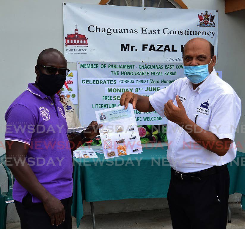 HELPING HAND: Chaguanas East MP Fazal Karim, right, hands over a seed growth packet to a constituent earlier this week.  - 