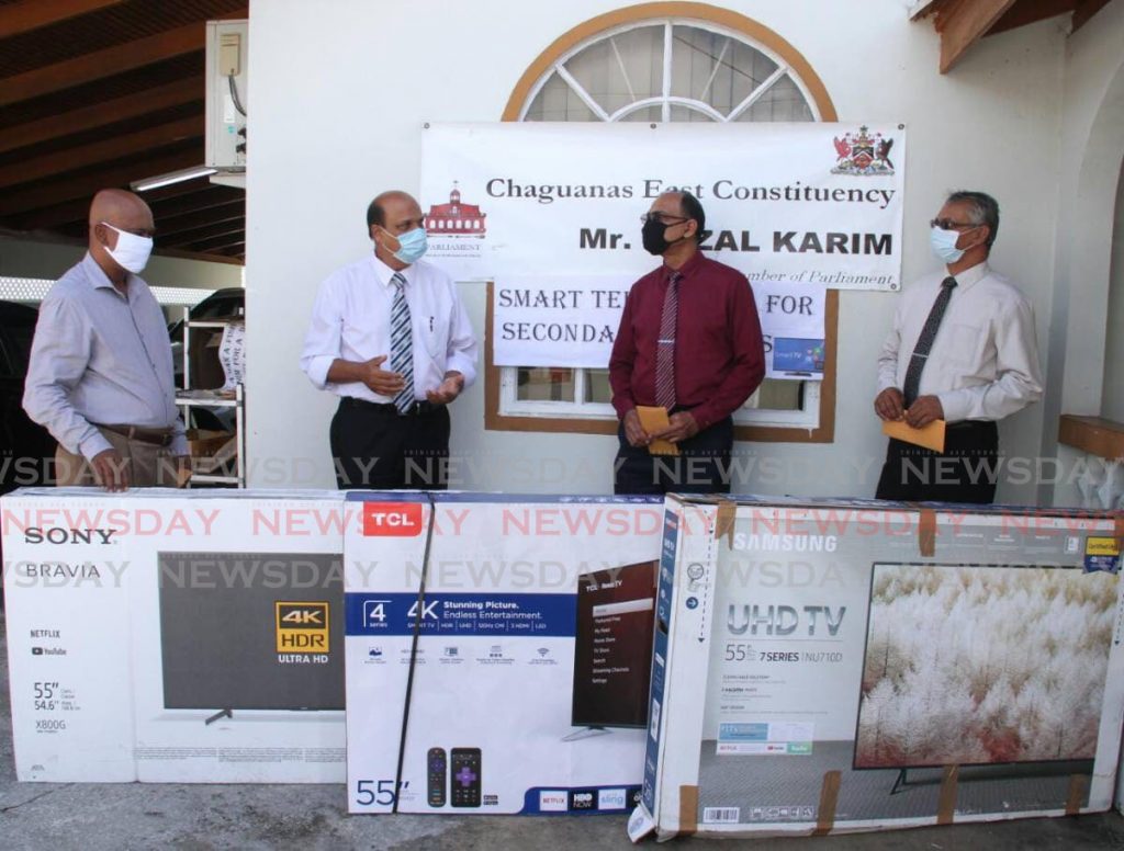 HELPING HAND: Chaguanas MP Fazal Karim, 2nd from left, with the smart televisions which he donated on Monday to three schools within his constituency. Also in photo from left are principals Kelly Birjur (Chaguanas North Sec), Bharat Maharaj (Chaguanas South Sec) and Lochan Harrichan of  Cunupia Secondary. PHOTO COURTESY CHAGUANAS EAST CONSTITUENCY OFFICE - Chaguanas East Constituency Office