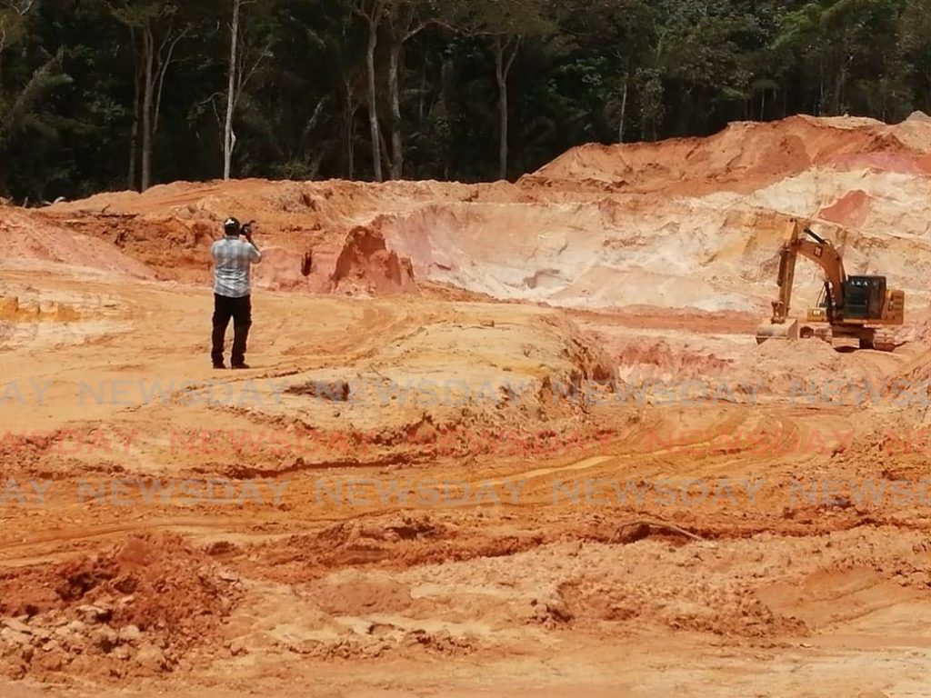 A  police officer takes video footage at the quarry site in Las Lomas on Wednesday. The quarry was shut down by the Ministry of Energy for operating without a licence. - Darren Bahaw