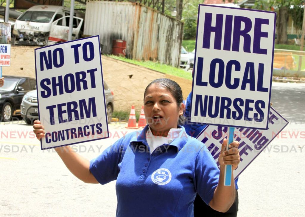 This nurse holds he placard during a protest at the St. Ann's Hospital against temporary employment and poor working conditions. - Ayanna Kinsale