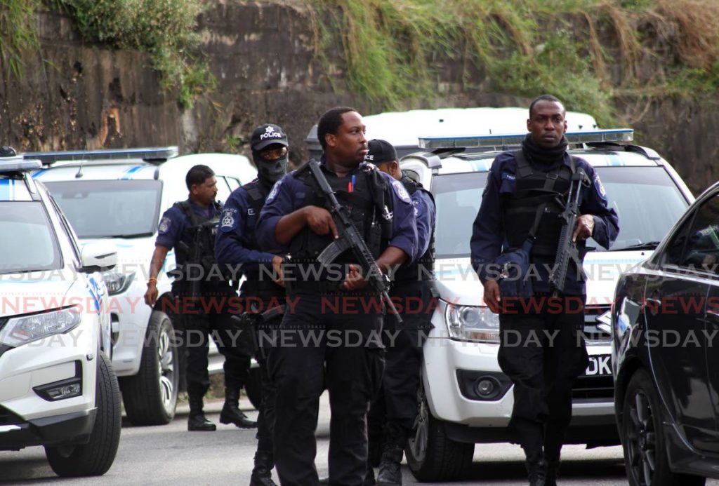 Police officers at the scene where three men were shot dead by cops in Morvant on Saturday. - ROGER JACOB