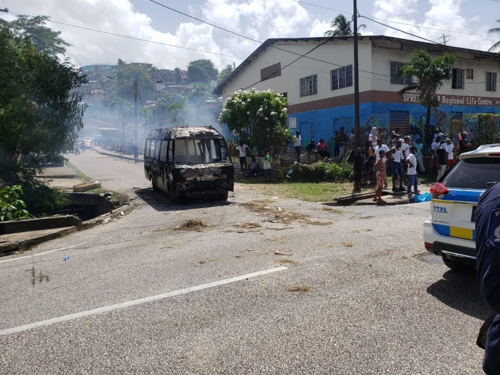 A maxi taxi burnt along the Eastern Main Road on Tuesday. Photo by JEFF K MAYERS