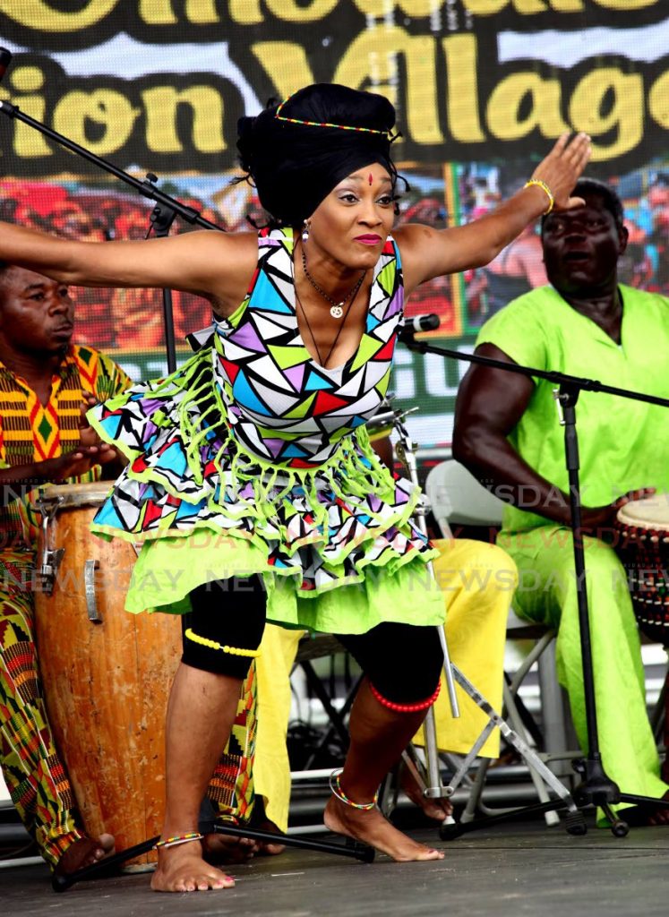 File photo: Trinidad’s Lisa Mc Clashie dances with Ghana’s Sankofa drummers at last year’s opening of the Lidj Yasu Omawale Emancipation Village at the Queen’s Park Savannah.  Photo by Sureash Cholai