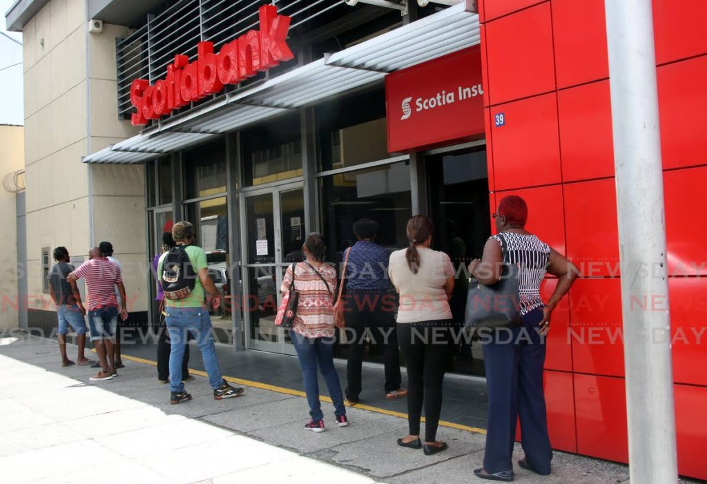 Customers wait to enter Scotiabank, Park Street, Port of Spain on March 27. The bank has announced its insurance business, ScotiaLife, will no longer be sold to Sagicor by mutual agreement. - Sureash Cholai