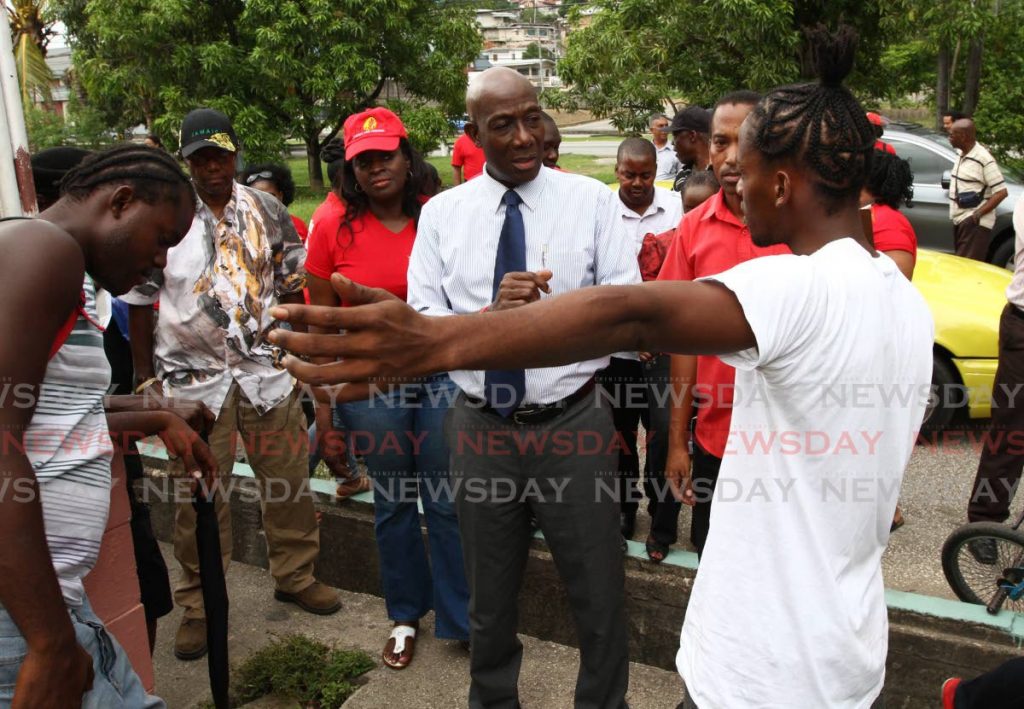 In this September 4, 2013 file photo Dr Keith Rowley, opposition leader at the time, listens to young residents Jason Kennedy and Romeo Blackman, who raised concerns about unemployment and stigmatisation, during a walkabout in Beetham. A Youth Votes Matter campaign has found the same issues may deter young voters from voting in the August 10, 2020 general election. Rowley is seeking re-election for a second term as Prime Minister following on the PNM's victory in 2015. FILE PHOTO/ROGER JACOB 