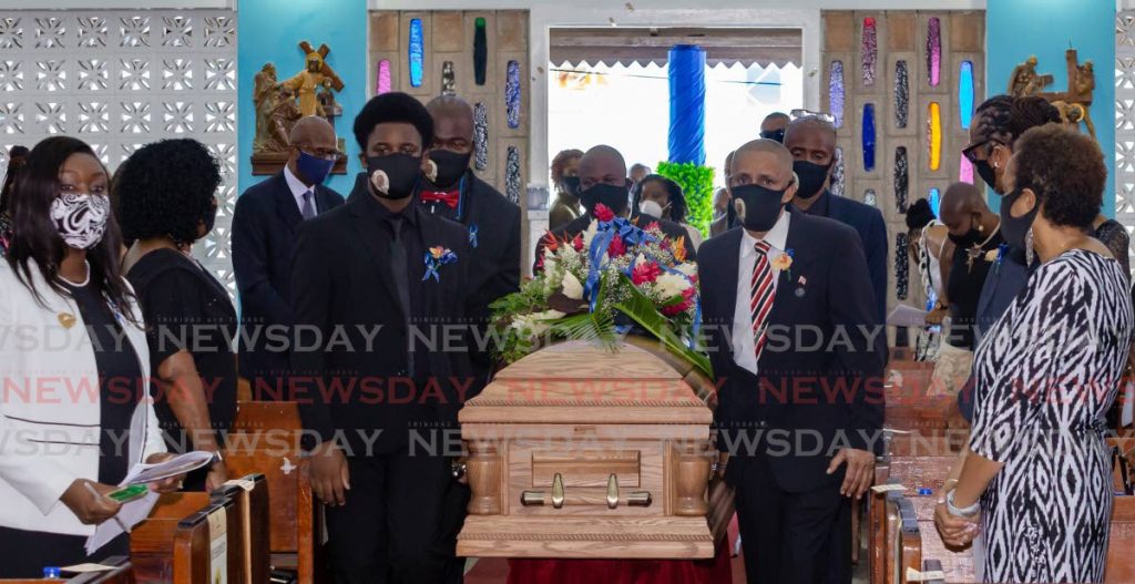 FINAL RITES: Nigel Wilson, right, helps carry the coffin of his father, former PNM Tobago Council chairman Neil Wilson, on Monday at St Andrew's Anglican Church in Scarborough. PHOTO BY DAVID REID - 