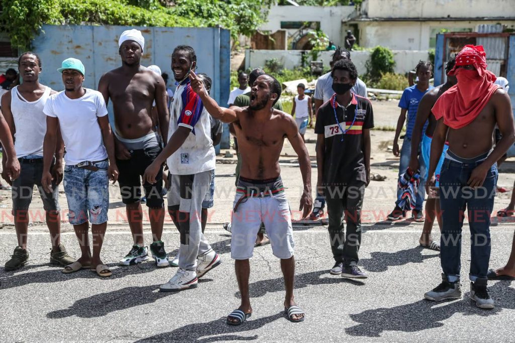 Protesters in East Port of Spain raise their voices in anger toward police over the killing of three men in Morvant last Saturday. - Jeff Mayers