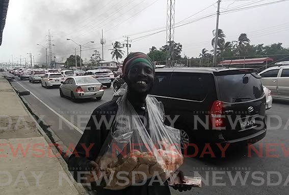 BUSINESS BOOMS: Nutsman John Nigel did a good trade on Tuesday as frustrated drivers caught up in traffic in Port of Spain called out to him for nuts, water and juice. PHOTO BY RYAN HAMILTON-DAVIS - Ryan Hamilton-Davis