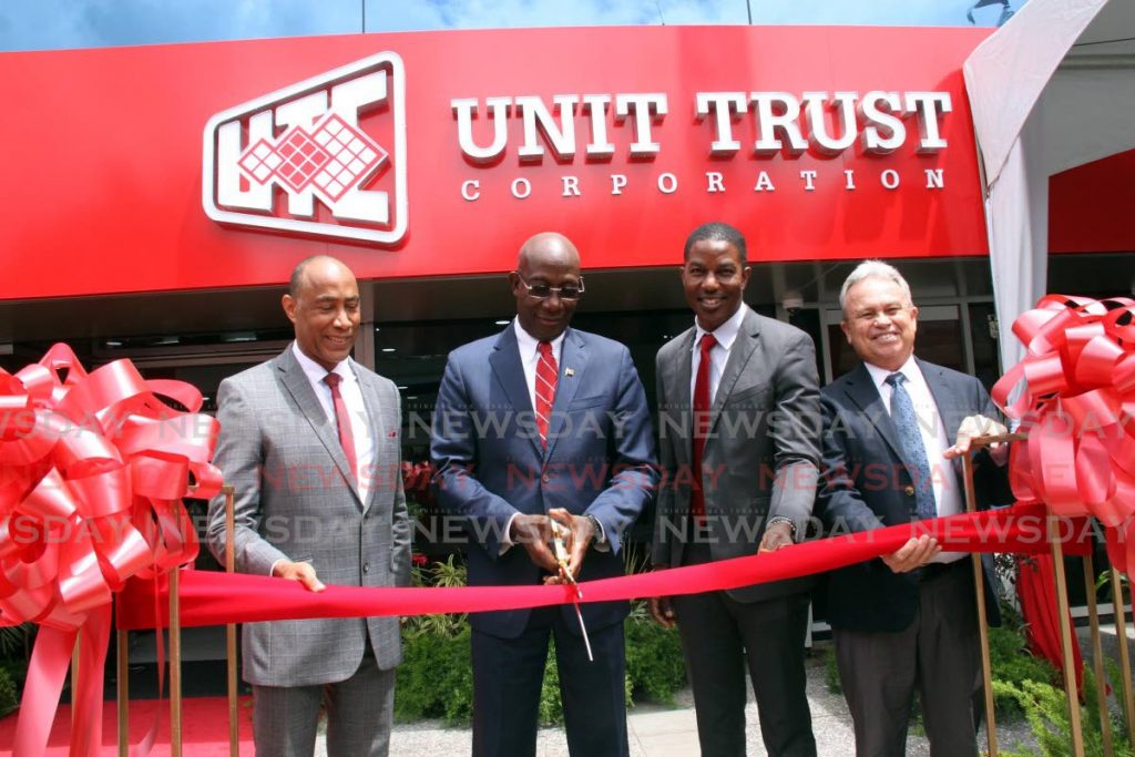 The Prime Minister (second from left) cuts the ribbon to open the Unit Trust Corporation's investment centre in San Fernando on Wednesday. Others in photo are UTC chairman Gerry Brooks, Nigel Edwards of UTC and Finance Minister Colm Imbert.    - Vashti Singh