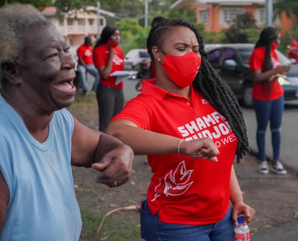 PNM Tobago West candidate and current MP Shamfa Cudjoe, right, touches elbows after a chat with one of her constituents on Monday. PHOTO COURTESY Shamfa Cudjoe Facebook - 