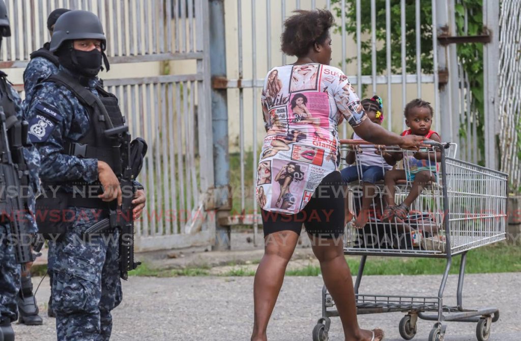 A policeman seems confused by the appearance of a woman taking her children for a 