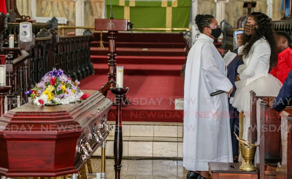 Anglican Dean, the Very Rev Shelley-Ann Tenia, speaks with Karene Asche whose father Errol Asche was laid to rest after a funeral at the Trinity Cathedral in Port of Spain on Wednesday. PHOTOS  BY JEFF MAYERS - 